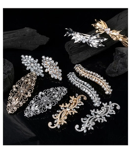 Detailed close-up of retro alloy hair clips with rhinestones and pearls on black surface