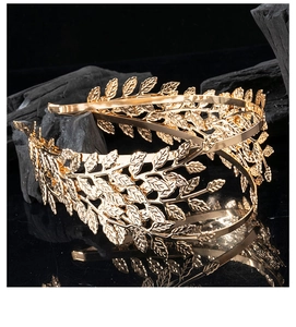 Detail of golden laurel leaf headband with metallic texture on black stone base