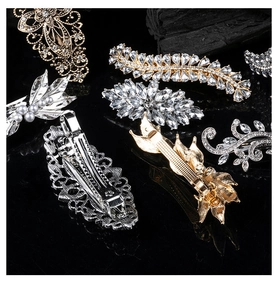 Detailed view of assorted alloy hair clips with crystals and pearls on dark background