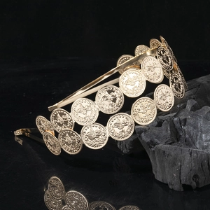 Elegant gold double-layered headband with vintage metallic coin charms on black surface