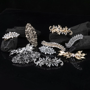 Vintage alloy hair clips with rhinestones and pearls on black charcoal base