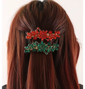 Détail de barrettes à fleurs en cristal rouge et vert sur cheveux bruns