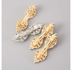 Detail view of retro rhinestone spring clips with embossed patterns and gold silver finishes