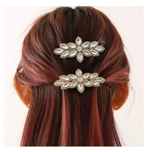 Detail view showing floral rhinestone hair clips in gold and silver on a model