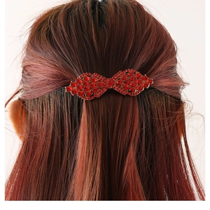 Sparkling red crystal bow hair clip shown on dark hair for elegant styling