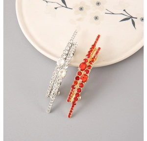 Detailed view of luxury rhinestone zigzag hairpins in red and silver finish