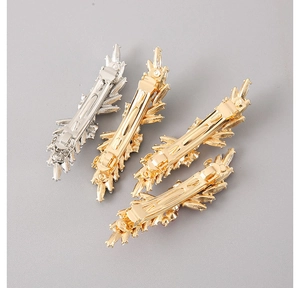 Detail view of gold and silver leaf-shaped alloy spring hair clips with intricate textures