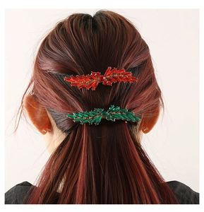 Detail showing red and green leaf hair clips with rhinestones on hair model back view