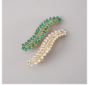 Detailed shot of emerald and clear crystal water-drop hair clips on gold alloy base