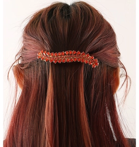 Detailed back view of a woman wearing a red rhinestone alloy spring hair clip on dark hair