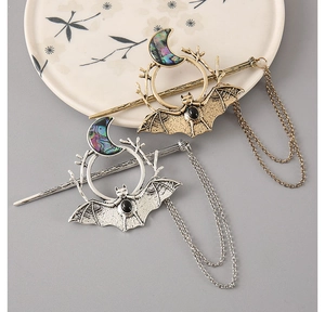 Detail of gothic bat crescent moon hair stick with abalone shell inlay and tassels