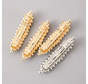 Detail von vier bunten Metall-Haarclips mit Struktur-Finish und Federverschluss