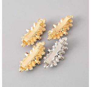 Detailed view of silver and gold metal spring hair clips with star-shaped rhinestones