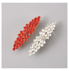 Detailed view of luxury gold hair clips with red and white pear-shaped zircons