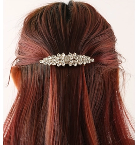 Detailed back view of a sparkling zircon hairpin styled on long reddish-brown wavy hair