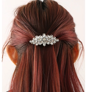 Detailed back view of a sparkling floral rhinestone hair clip on smooth reddish-brown hair