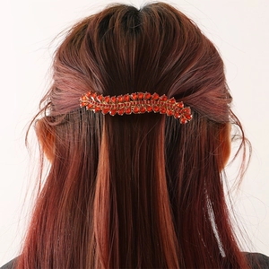 Elegant gold alloy spring hair clip featuring sparkling red rhinestones on wavy design