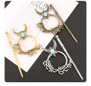 Detailed view of bohemian moon and branch hair sticks with turquoise stones in metal alloy