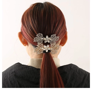 Detailed view of leaf design rhinestone hair clip worn on model with elegant crystal finish