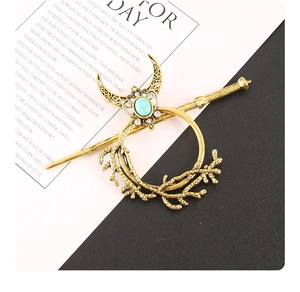 Detailed view of vintage gold branch ring base with turquoise crescent moon hair accessory