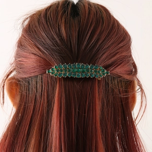 Eleganter goldener Haarclip mit grünen Tropfenkristallen auf rotbraunem Haar, Rückansicht