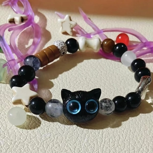 Macro shot of handcrafted black cat bead bracelet with star and bone charms on leather