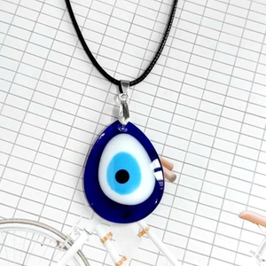 Detalle macro del colgante de ojo turco de cristal azul en forma de gota azul