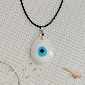 Detalle macro del colgante de gota del ojo turco con centro de cristal azulado