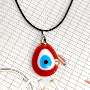 Detalle de un colgante de ojo turco de 3 cm de cristal en un collar de cordón negro
