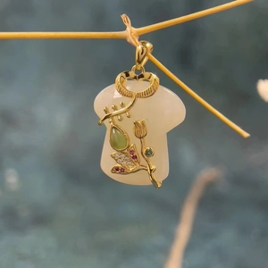 Elegant gold-plated jade pendant necklace with floral metal inlay on a withered branch