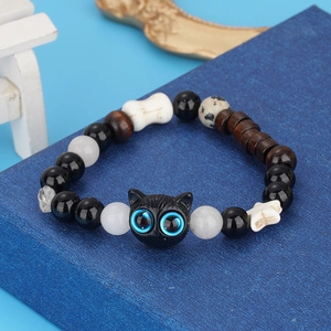 Gothic beaded cat bracelet with black beads, white cross and bone charms on display