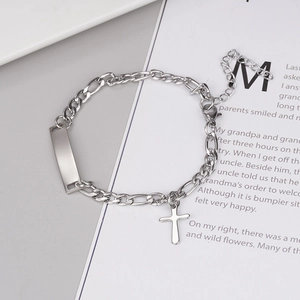 Détail du bracelet chaîne Figaro argenté avec breloque croix et pendentif rectangulaire