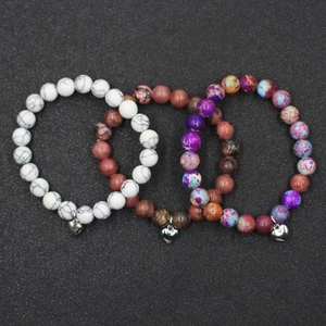 Detalle del conjunto de 3 pulseras de cuentas de piedra natural con dijes de corazón plateados