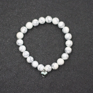 Vista superior detallada de la pulsera de cuentas de mármol blanco con dije de corazón