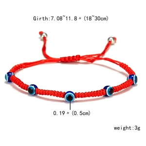 Detailed view of red braided rope bracelet with blue evil eye beads and adjustable drawstring