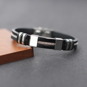 Modern men's black silicone bracelet with stainless steel mesh center and metal accents