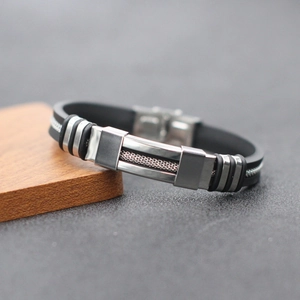 Detail of men's stainless steel bracelet with black silicone band and mesh texture