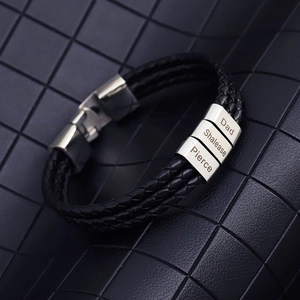 Close-up of triple-layer braided leather bracelet with three custom engraved name rings