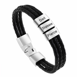 Macro shot of custom engraved metal beads on a braided leather bracelet for men