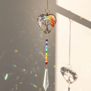 Macro shot of heart-shaped Tree of Life suncatcher casting rainbow prism reflections