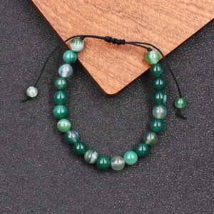 Detail van groene agaat kralenarmband met verstelbaar zwart gevlochten koord en steen