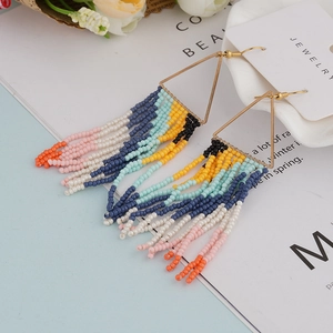 Detail of bohemian handmade colorful bead fringe earrings with gold triangular frame