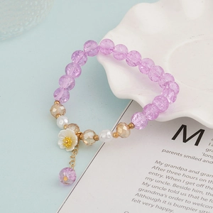 Detailed close-up of beaded crystal bracelet with purple flowers and white pearls
