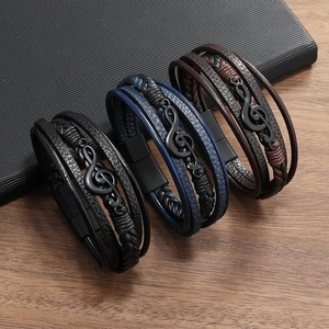 Dettaglio di bracciali in pelle multistrato con chiave di violino e chiusura magnetica