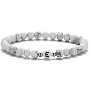 Gros plan du bracelet en perles turquoise blanche 6mm avec entretoises et lettre E