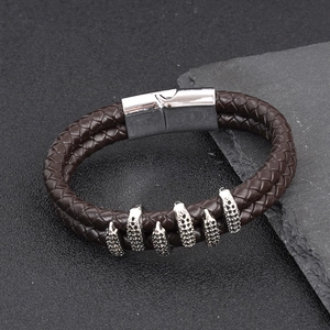 Detail view of double-strand brown leather bracelet with silver magnetic buckle and claw charms