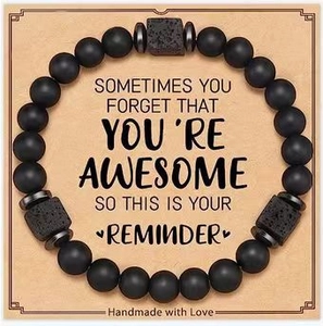 Matte black agate and lava stone beaded heart bracelet on a kraft gift card