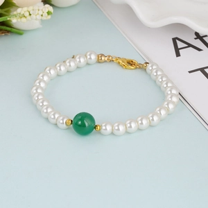 Elegant natural pearl bracelet with a large green gemstone bead and gold lobster clasp