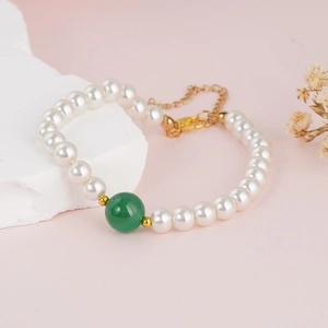 Elegant natural pearl bracelet with a green centerpiece and adjustable gold chain