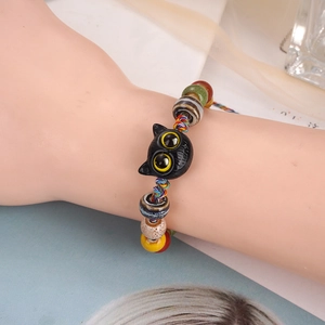 Colorful hand-woven rope bracelet with a ceramic cat charm and patterned beads for women